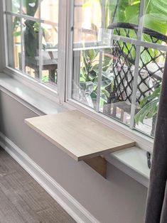 a window sill sitting next to a wooden shelf