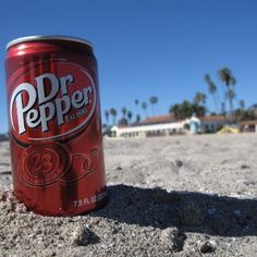 a can of dr pepper on the beach