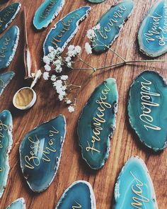 some blue agate with writing on them and flowers in the middle, sitting on a wooden table