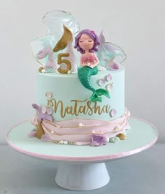 a mermaid themed birthday cake with the number five on it