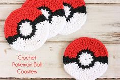 three crocheted pokemon ball coasters sitting on top of a white wooden table