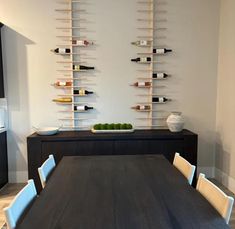 a dining room table with wine bottles on the wall