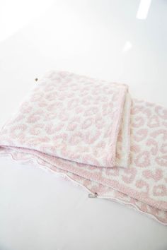 two pink towels sitting on top of a white table