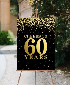 a sign that says cheers to 60 years on it with gold confetti in the background