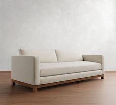 a white couch sitting on top of a hard wood floor