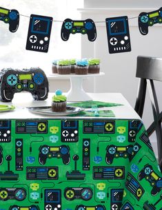 some cupcakes are sitting on a table with video game controllers hanging from it