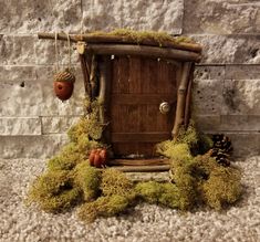 a small wooden door with moss growing on the outside and an acorn hanging from it's side