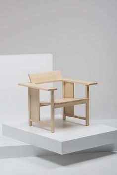 a wooden chair sitting on top of a white platform