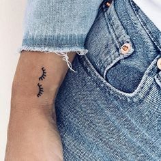 a person with a small tattoo on their left wrist and the other arm behind her