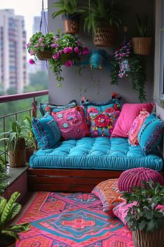 a couch with colorful pillows on top of it next to plants and potted plants