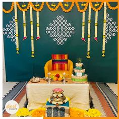 a table topped with cakes and desserts next to a wall covered in string lights