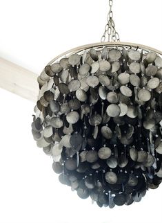 a chandelier hanging from the ceiling with lots of stones on it's chain