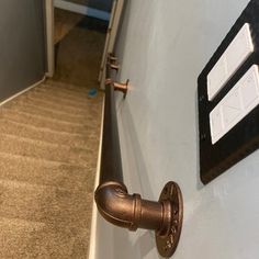 a door handle on the side of a wall next to a carpeted stair case