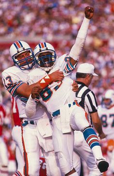 two football players hugging each other on the field