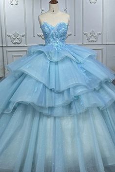 Step into a fairytale with this romantic princess quinceanera dress. This enchanting dress is made from delicate lace fabric in a dreamy sky blue color. The strapless neckline and sleeveless design create an elegant look, while the cathedral train adds a touch of grandeur to this dress. With the appliqued details and ruffled embellishments, this gown is perfect for making your quinceanera celebration unforgettable. Details: Silhouette: Ball Gown Style Fabric: Lace Fabric Color: Sky Blue Color Le Blue Quince Dress, Dreamy Sky, Sequin Ball Gown, Romantic Princess, Enchanting Dress, Blue Quince, Pretty Quinceanera Dresses, Quince Dress, Cathedral Train