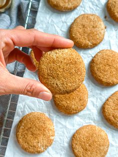 a person is picking up some cookies from a tray