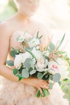 a woman holding a bouquet of flowers in her hands