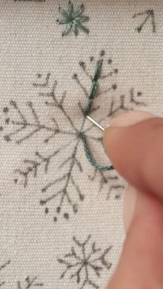 someone is stitching snowflakes on the fabric