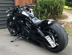 a black motorcycle parked in front of a garage