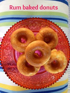 three donuts on a red plate with the words rum baked donuts above them