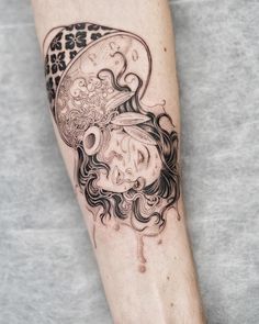 a person with a tattoo on their arm has a skull in the shape of a woman's head