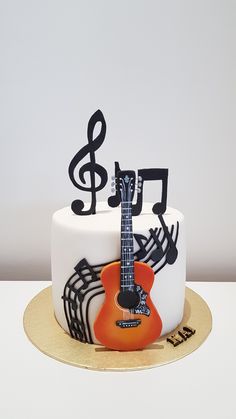 a cake decorated with musical notes and an orange guitar