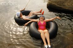 two women are floating on inflatable tubes in the water