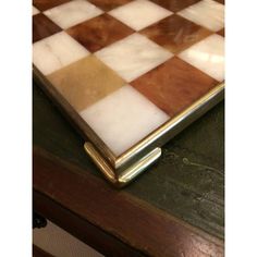 a close up of a chess board on a table with wood and metal trims