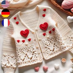 a crocheted sweater with red hearts on it and other items next to it