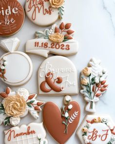 decorated cookies with names and date displayed on white countertop for wedding guests to eat