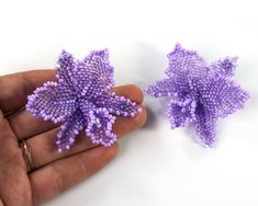 two small purple beads in the shape of flowers