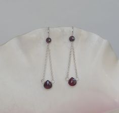 Lovely 6 x 6mm garnet faceted flat teardrops threaded on sterling silver headpins dangle from 1.5mm sterling silver rolo chain. The 25mm sterling silver long shank ear wires are embellished with 4mm rhodolite garnet faceted rounds. All of the gemstones are designer quality (B grade or better). The drop length is 1-3/4 inches. A travel pouch and gift box are included with every purchase. #1958 Nickel Free Briolette Teardrop Earrings In Sterling Silver, Nickel-free Briolette Teardrop Sterling Silver Earrings, Sterling Silver Faceted Teardrop Dangle Earrings, Faceted Sterling Silver Teardrop Dangle Earrings, Silver Chain Earrings, Santa Margarita, Rhodolite Garnet, Rolo Chain, Gift Jewelry