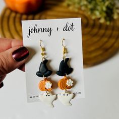 a pair of halloween themed earrings is shown in front of a card that says johnny and dot