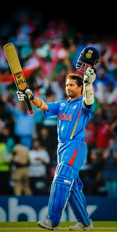 a cricket player holding his bat up in the air