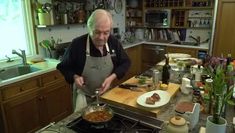 an older man is cooking in the kitchen