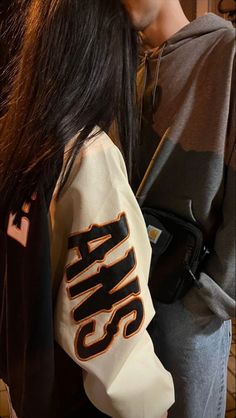 a woman with long black hair wearing a jacket that says krss on it