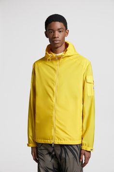 Designed to provide protection, the Etiache jacket is crafted from rainwear, a compact nylon fabric, notable for its water-repellent properties. Inspired by the iconic Moncler Maya, the hooded jacket is finished with a signature patch pocket on the sleeve. Yellow Waterproof Nylon Windbreaker, Waterproof Yellow Nylon Windbreaker, Nylon Windbreaker With Drawstring Hood For Rainy Weather, Yellow Weatherproof Nylon Outerwear, Yellow Waterproof Windbreaker For Spring, Nylon Windbreaker With Detachable Hood For Rainy Weather, Sporty Nylon Raincoat With Detachable Hood, Spring Yellow Waterproof Windbreaker, Functional Nylon Raincoat With Drawstring Hood