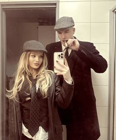 a man and woman taking a selfie in the bathroom mirror with their cell phones