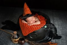 a newborn baby wearing a witches hat and sleeping in a witch's caulder