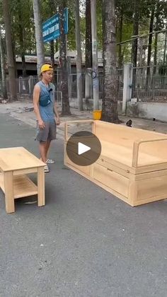 a man standing in the middle of a street next to wooden benches and coffee tables