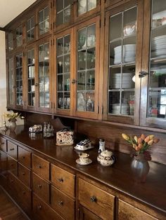 a kitchen with wooden cabinets and glass doors