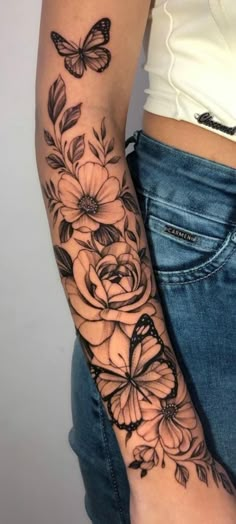 a woman's arm with flowers and butterflies on it