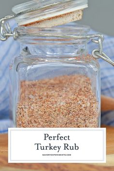 a glass jar filled with turkey rub on top of a wooden cutting board