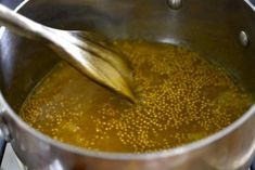 a pot filled with yellow liquid and a wooden spoon