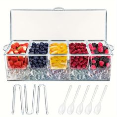 plastic containers filled with different types of fruit and silverware next to utensils