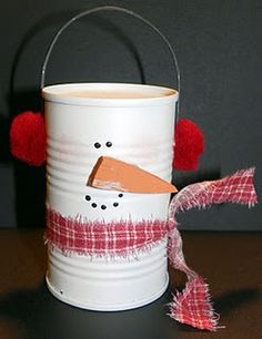 a tin can with a snowman on it and some red pom - poms