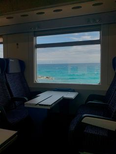 an empty train car with two seats facing the ocean