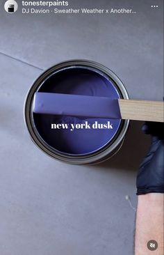 a person holding a paint can with the words new york dusk painted on it in white