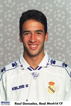 a soccer player is posing for a photo in front of a wall with paw prints