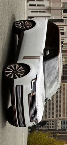 an aerial view of a white car parked in front of a tall building